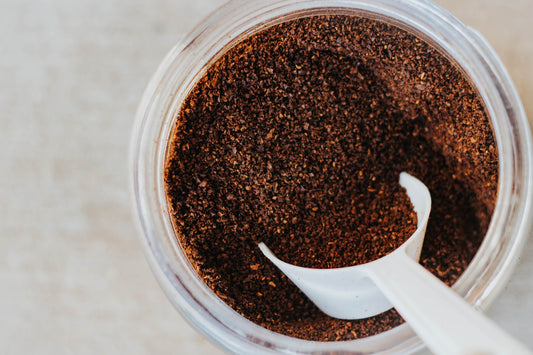 White table spoon on coffee grounds