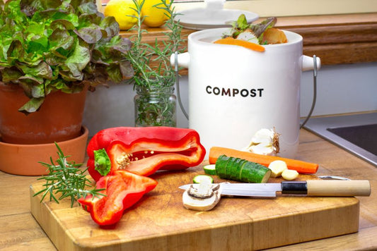 Food scraps into a white bin labeled compost