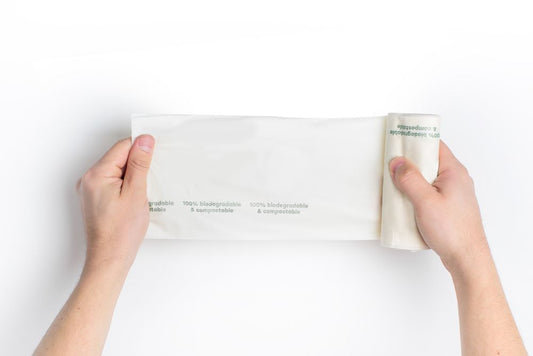 hands unrolling biodegradable bags