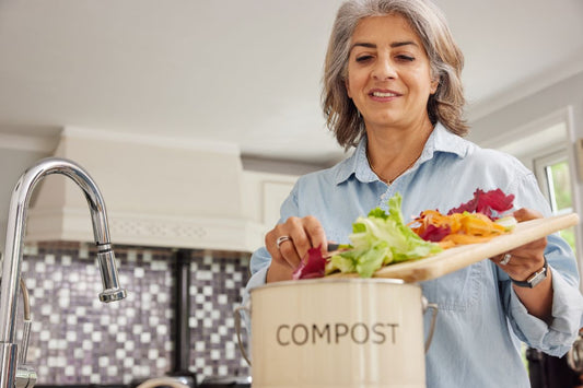 woman adding more compost ready materials to bin