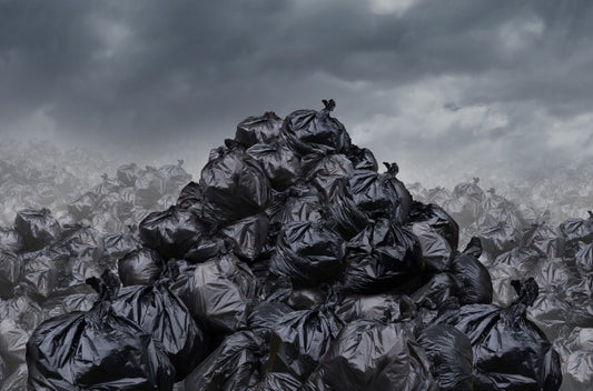 Several piles of filled up black garbage bags